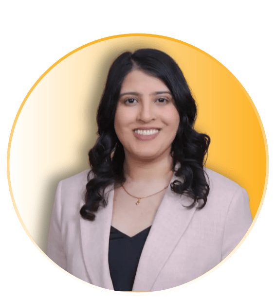 Kinjal Shah smiling in a light gray blazer and black top with a gold necklace inside a circular frame with a gold accent border
