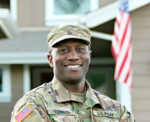 austin tidwell standing in military uniform with arms crossed smiling